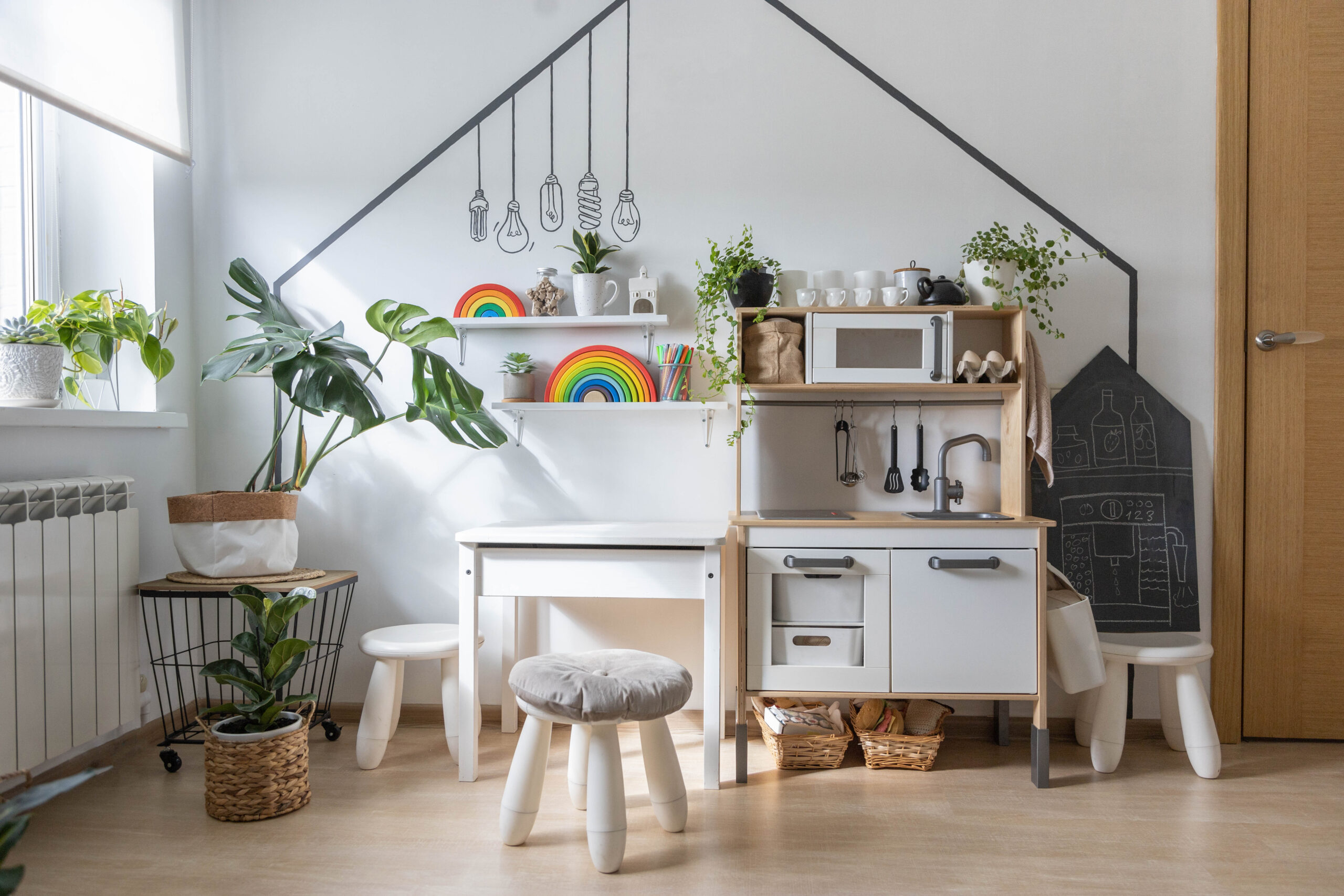 White childish kitchen interior early development playroom with Montessori wooden materials